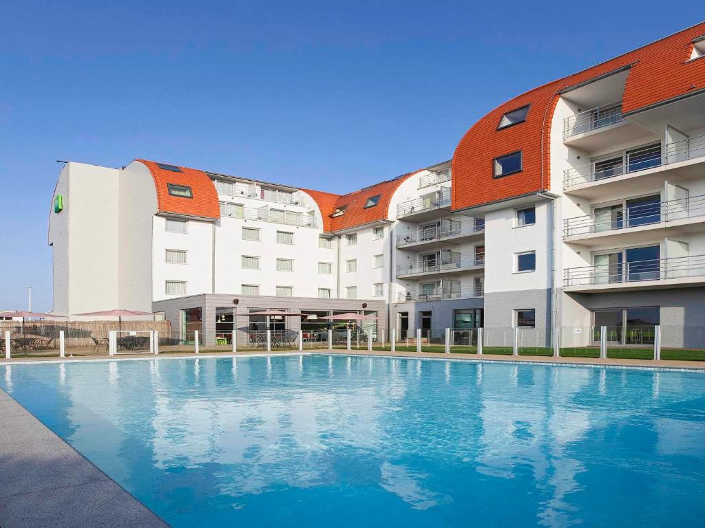 a swimming pool in front of a building at Holiday Suites Zeebrugge in Zeebrugge