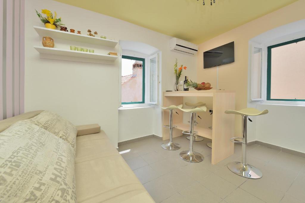 sypialnia z łóżkiem, biurkiem i 2 stołkami w obiekcie Apartments Carpe Diem w mieście Novigrad