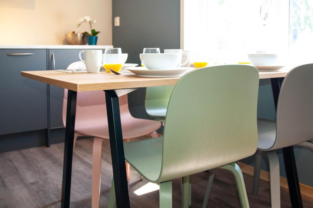 a dining room table with four chairs and a wooden table at Maya Apartments - Kasjotten in Lillestrøm