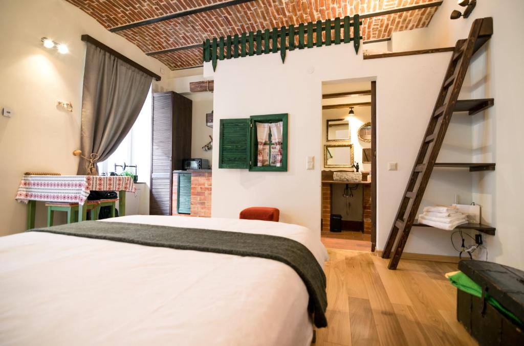 a bedroom with a bed and a ladder at Folkloric Loft-Ulița Românească in Sibiu