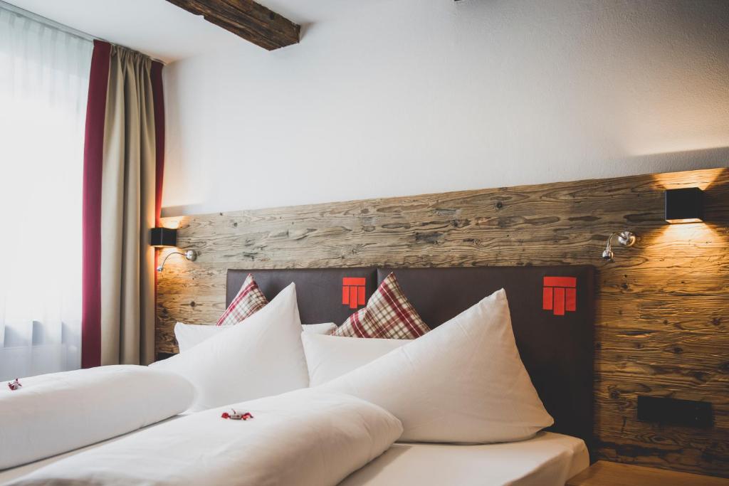 a row of white pillows on a bed in a room at Hotel Montfort in Sankt Anton am Arlberg