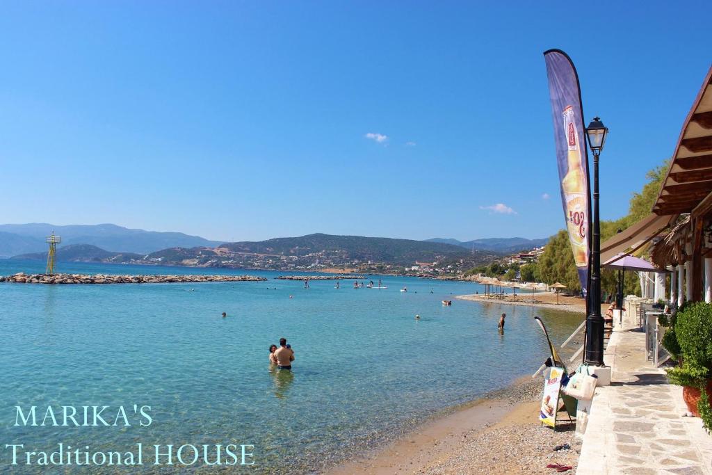a beach in a town with people in the water at Marika's Traditional House in Agios Nikolaos