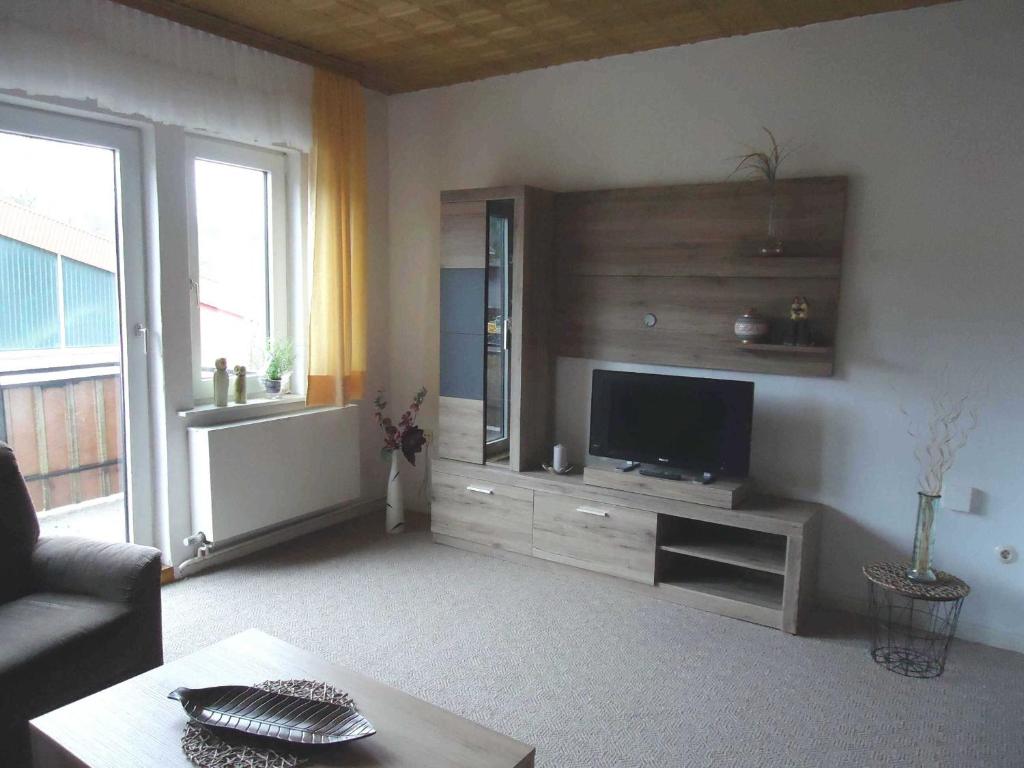 a living room with a flat screen tv on a wall at Ferienwohnung Lautenbach in Bad Sachsa