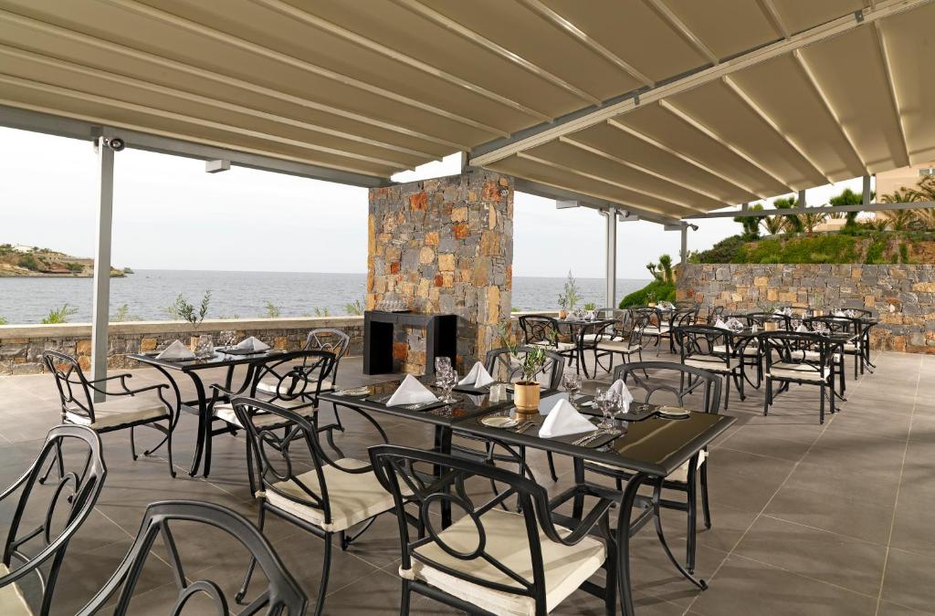 a group of tables and chairs on a patio at Out Of The Blue Resort & Spa in Agia Pelagia