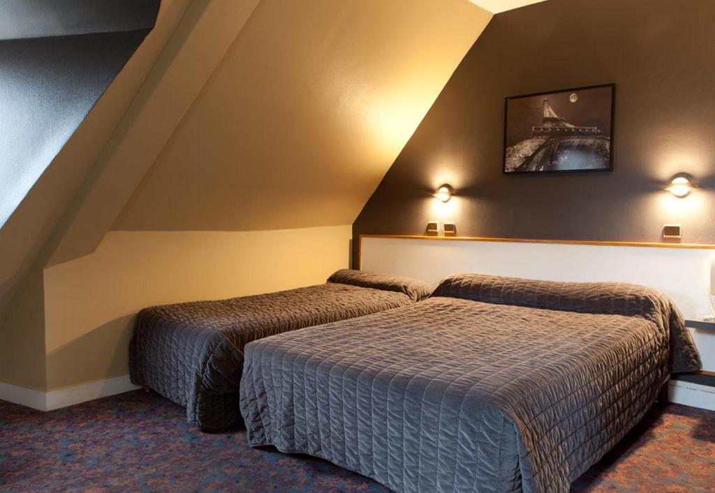 a hotel room with two beds in a room at Grand Hôtel De Paris in Paris
