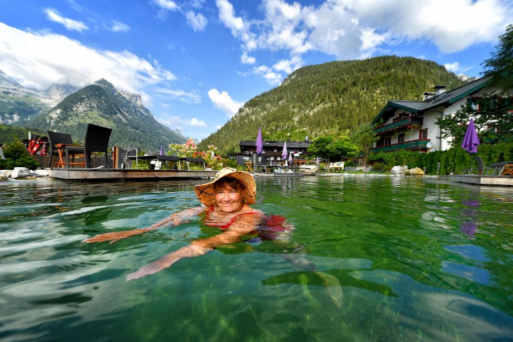a young girl swimming in a body of water at Familien- und Vitalhotel Mühlpointhof in Lofer