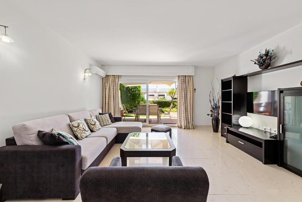 a living room with a couch and a tv at Victory Village 2A in Quinta do Lago