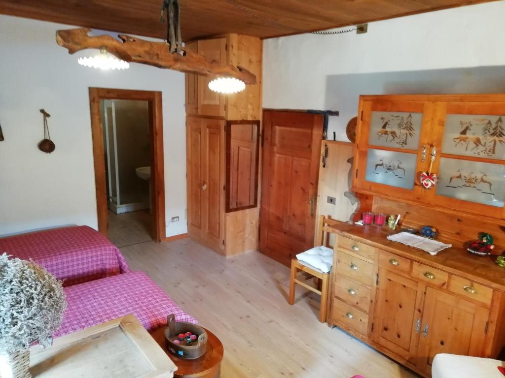 ein Wohnzimmer mit einem Bett und einer Kommode in der Unterkunft Al Piz Monolocale in Colle Santa Lucia