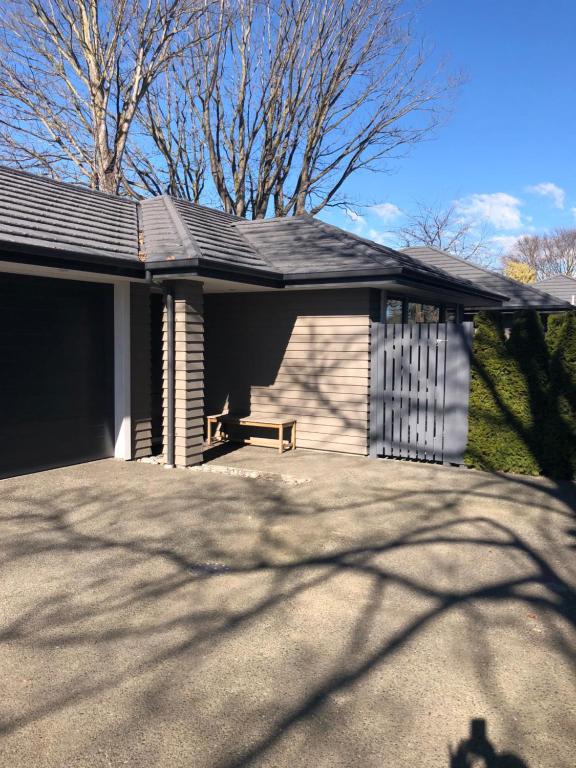 a house with a shingled roof and a driveway at Memorial holiday home in Christchurch