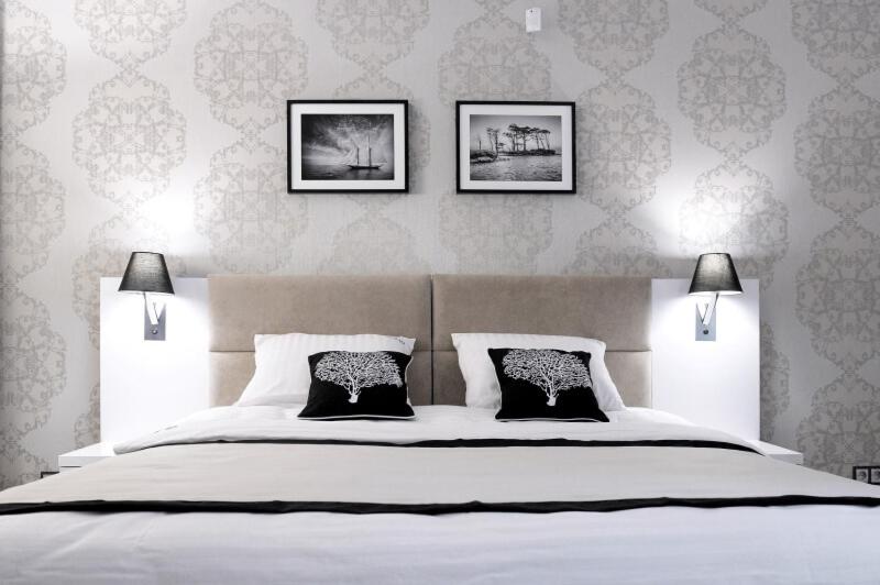 ポビエロボにあるWilla Cicho Szaのベッドルーム1室(壁に3枚の写真が飾られた白い大型ベッド1台付)