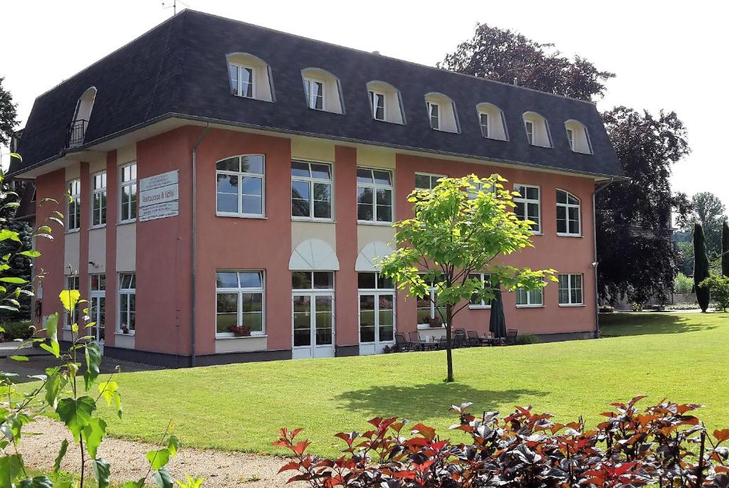 ein großes Gebäude mit einem Baum davor in der Unterkunft Vzdělávací Středisko a Hotel in Varnsdorf