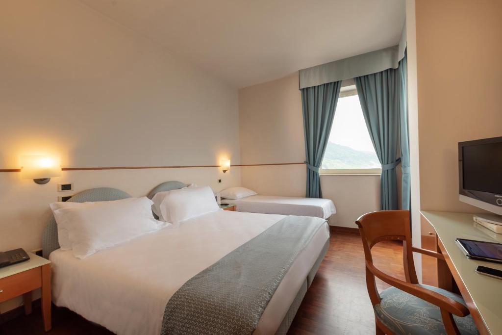 Postel nebo postele na pokoji v ubytování Hotel Baia Flaminia