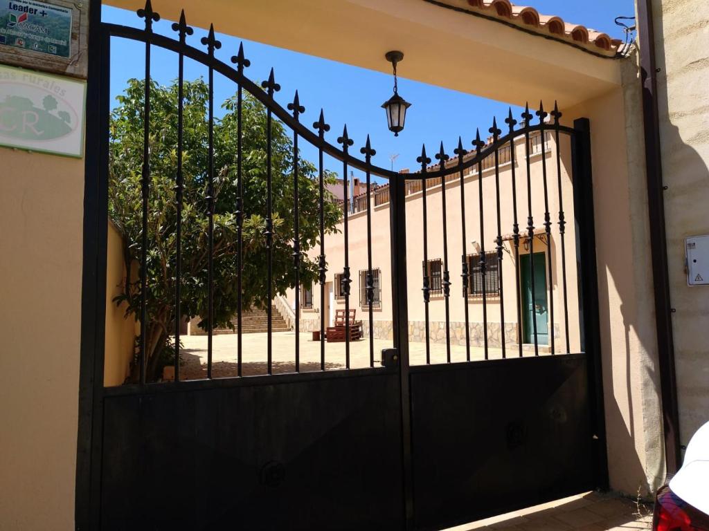 Una puerta negra con un árbol detrás. en Casas Rurales Montemayor, en Casas de Lázaro