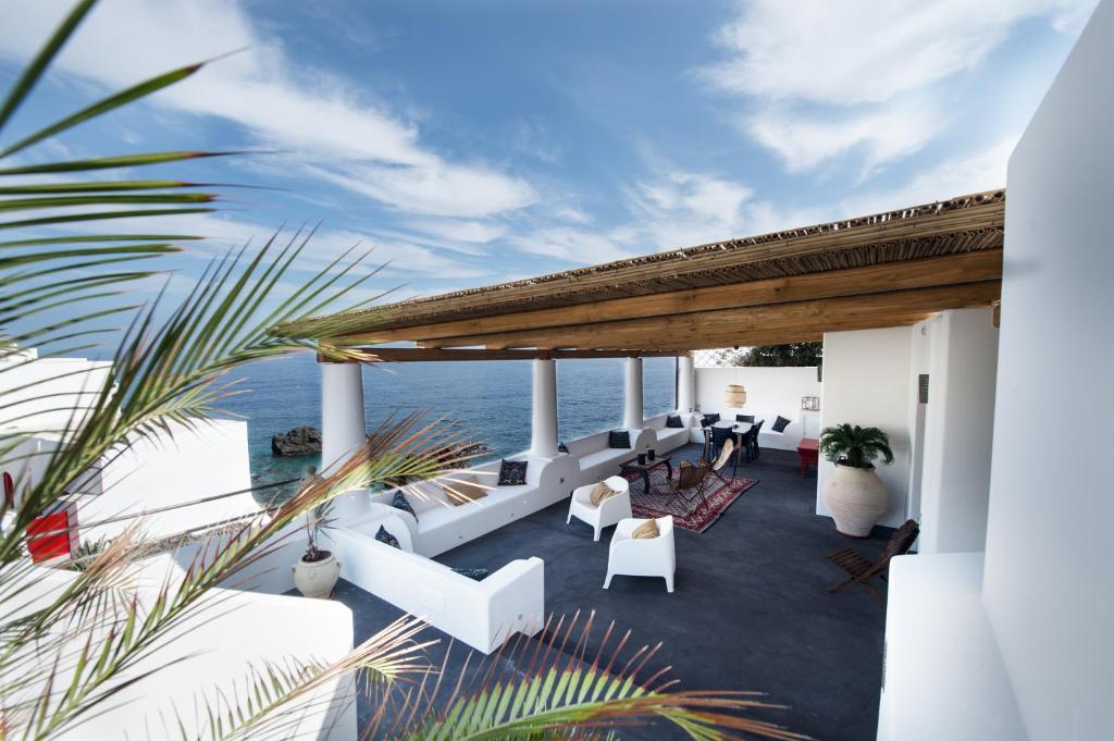 einen Balkon mit weißen Möbeln und dem Meer im Hintergrund in der Unterkunft Casa 34 Dicembre in Stromboli