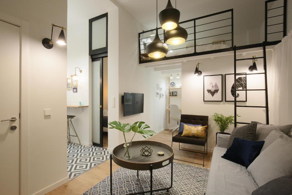 een woonkamer met een bank en een tafel bij Moderno y reformado apartamento al lado del Museo in Madrid