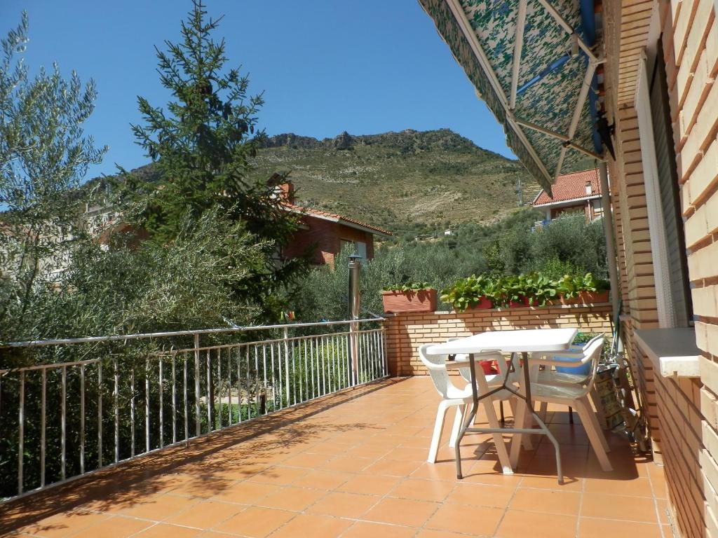 patio con mesa y sillas en el balcón en Casa Con Encanto En Arnedillo, en Arnedillo