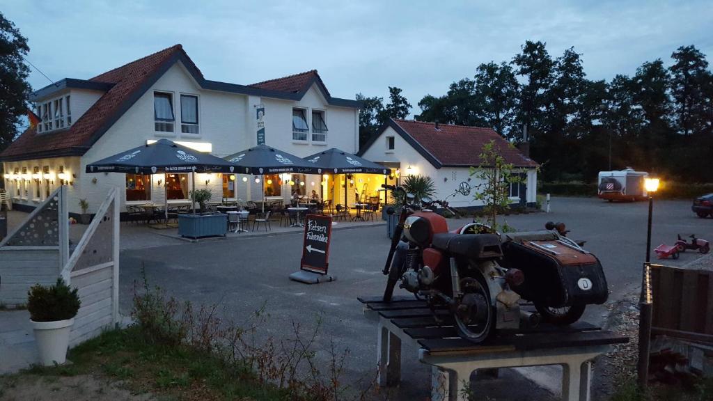 een motorfiets op een tafel voor een gebouw bij De Twentse Nar in De Lutte