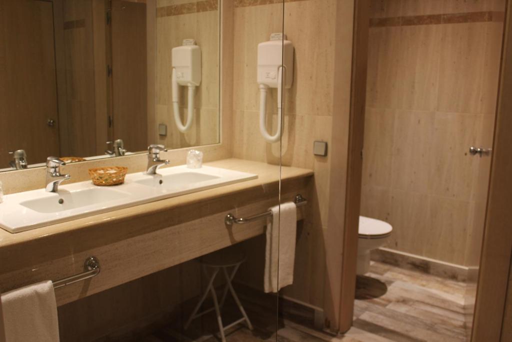 a bathroom with a sink, toilet and mirror at Sercotel Hotel Palacio del Mar in Santander
