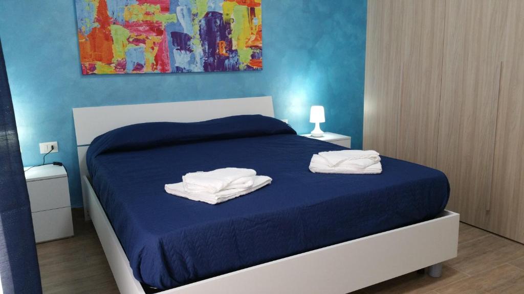 - une chambre avec un lit bleu et 2 serviettes dans l'établissement Piazza Repubblica appartament, à Alcamo