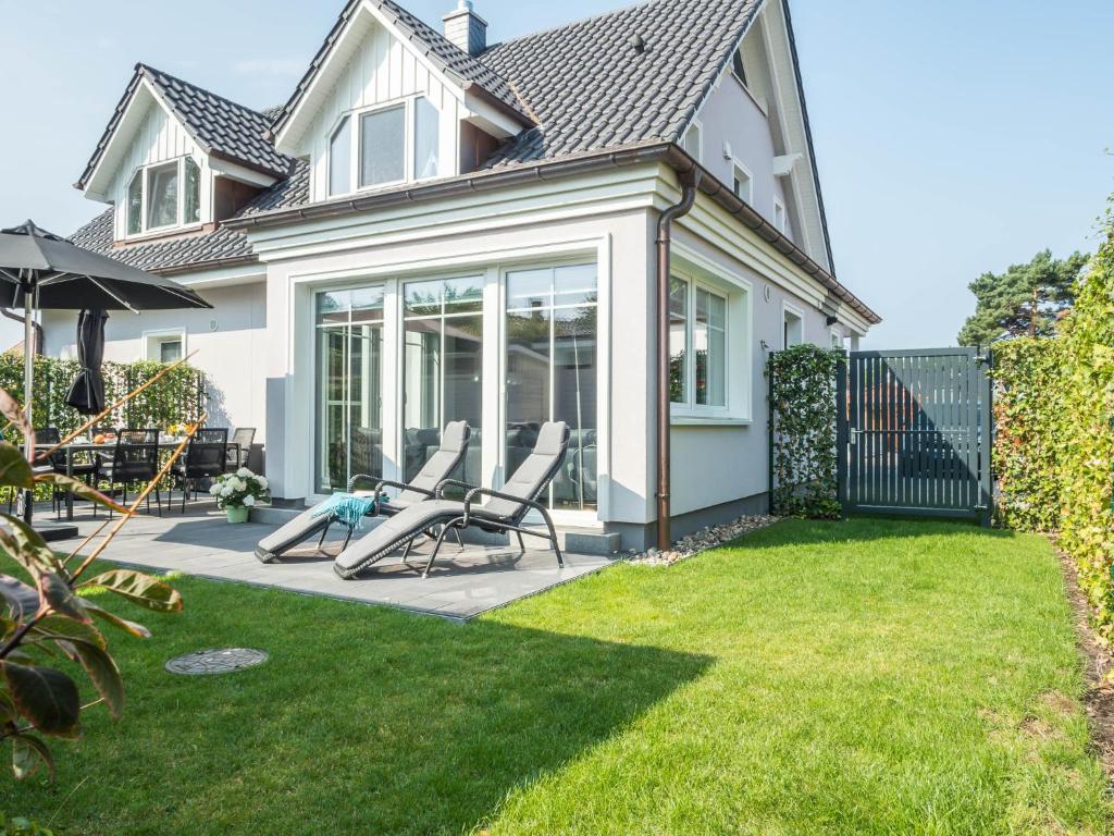 uma casa com duas cadeiras num pátio em Haus Therese mit Sauna em Zingst