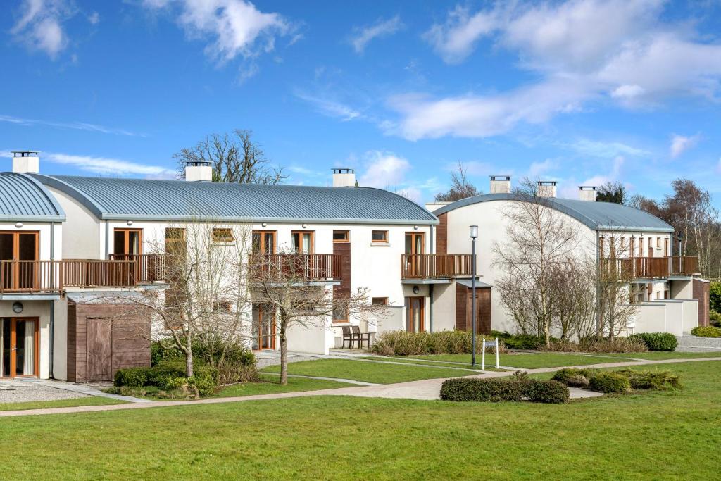 una gran casa blanca con un patio verde en The Johnstown Estate Lodges en Enfield