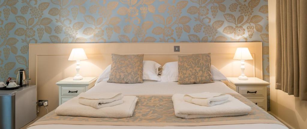 a bedroom with a bed with two pillows on it at Maison Gorey Hotel in Grouville