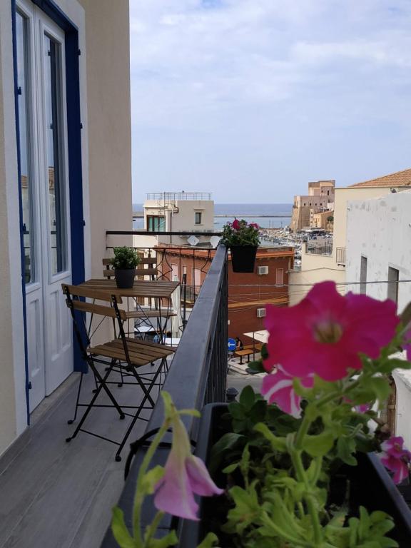 a balcony with flowers and a view of the ocean at Marina Blu Rooms in Castellammare del Golfo