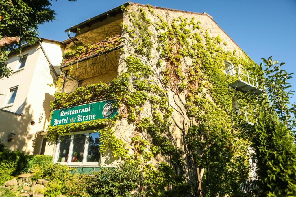 a building covered in ivy with a sign on it at Hotel Krone in Alsfeld