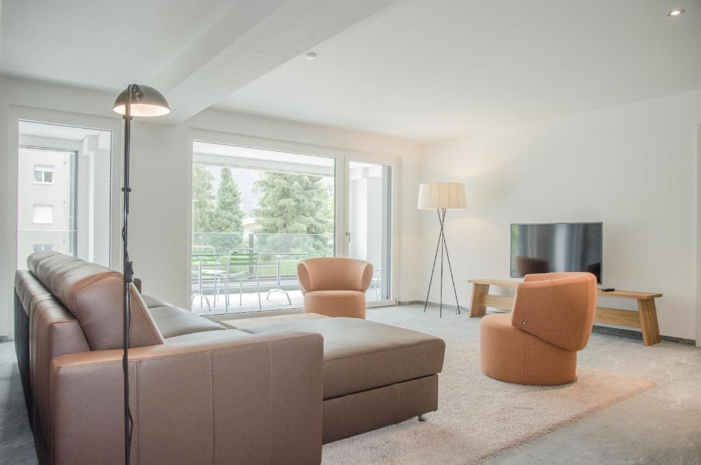 uma sala de estar com um sofá e duas cadeiras em Apartment JungfrauCenter Schynige Platte - GriwaRent AG em Interlaken