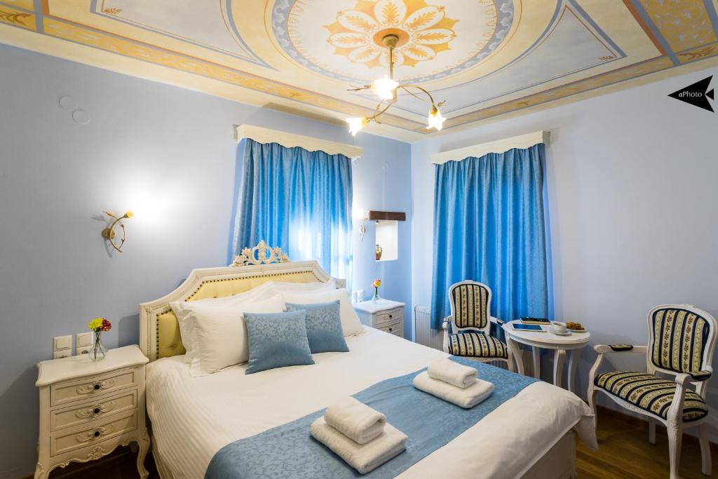 a bedroom with a large bed with blue curtains at Villa Paroraia in Tsepelovo