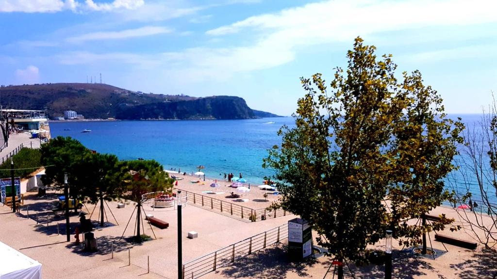 a view of a beach with people in the water at Apartments Himara Premium in Himare