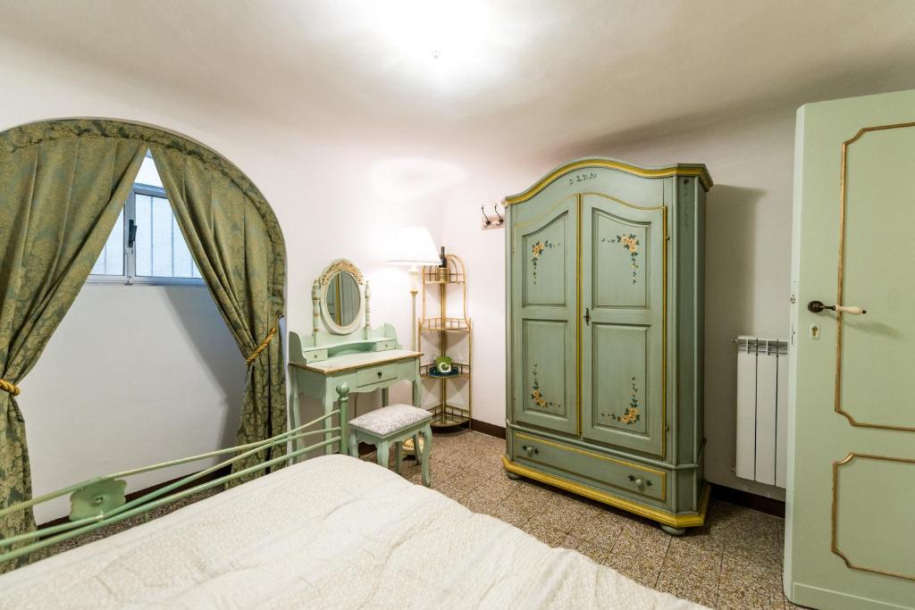 フィレンツェにあるCasa Savonarola Charmeの緑のキャビネットと鏡付きのベッドルーム1室