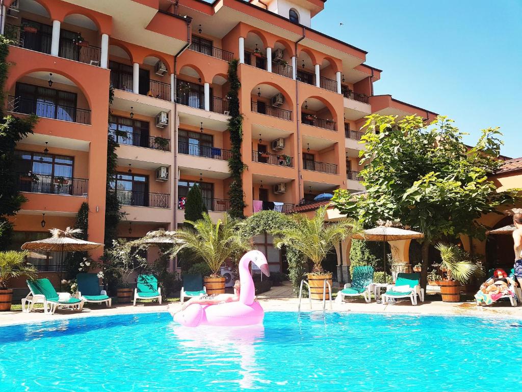 dois cisnes cor-de-rosa numa piscina em frente a um hotel em Hotel Liani - All Inclusive em Sunny Beach
