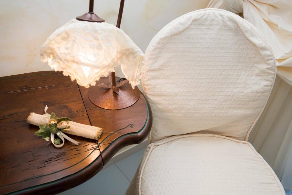 una sedia bianca accanto a un tavolo con una lampada di Silva Apartments ad Alberobello