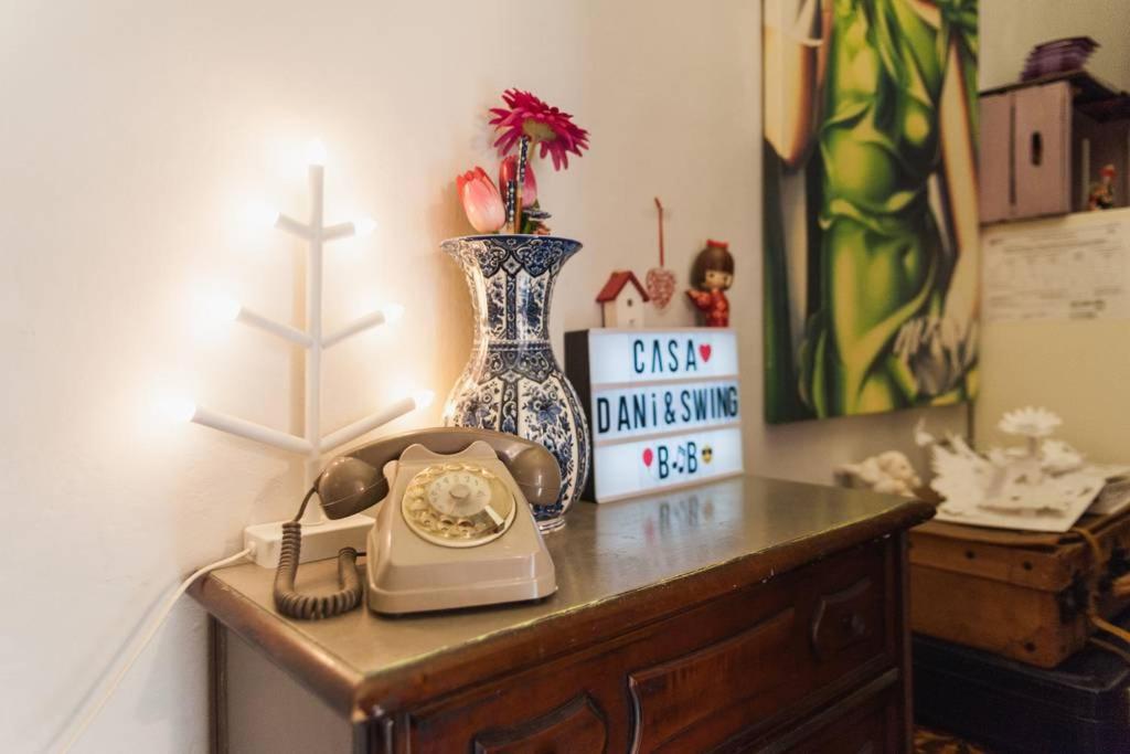a table with a telephone and a vase on it at Casa Dani&Swing Bed&Books in Turin
