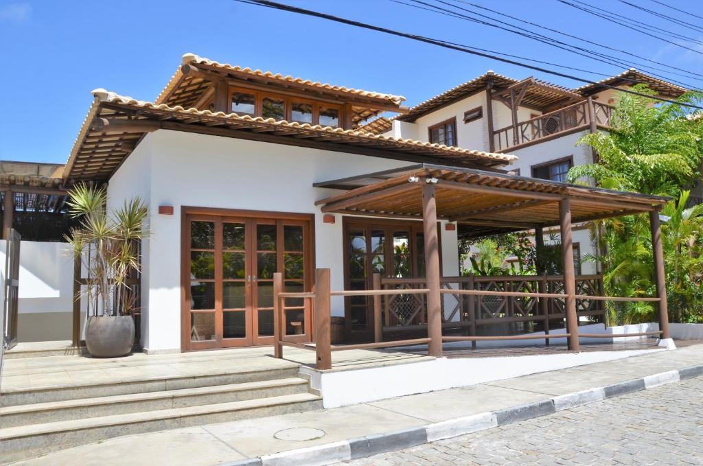 uma villa com um alpendre em frente a uma casa em Praia do Forte Luxuoso Village em Matta de São João