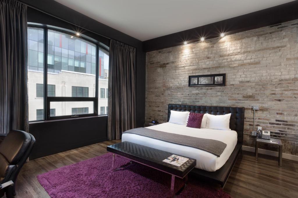 a bedroom with a large bed and a brick wall at Hotel Metro in London