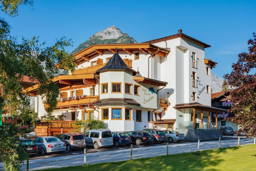 un grande edificio con auto parcheggiate in un parcheggio di Hotel Enzian a Pertisau