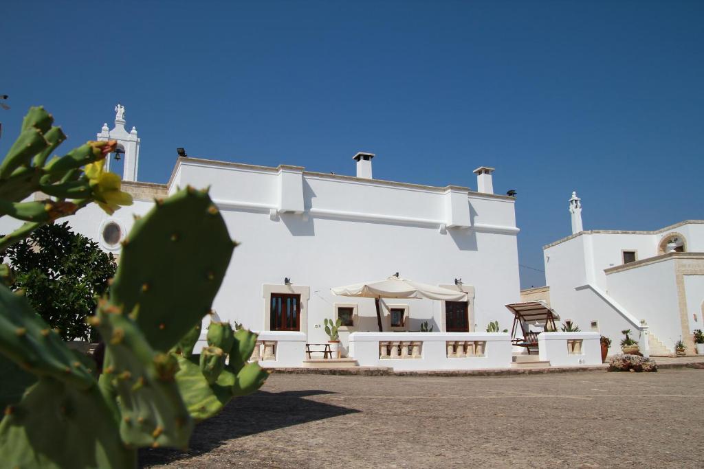 ein weißes Gebäude mit einem Kaktus davor in der Unterkunft Masseria San Martino in Fasano