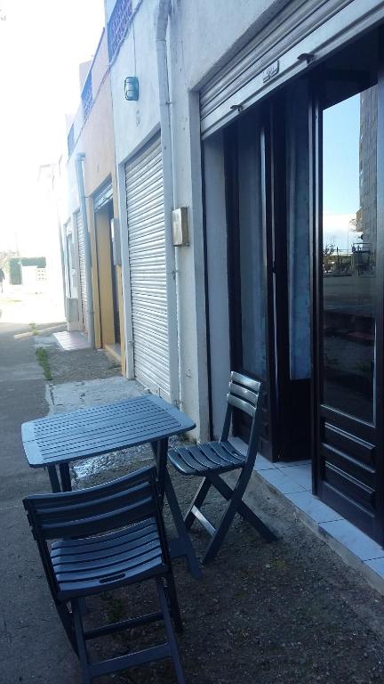 a picnic table and two chairs next to a building at 15 C/MUGA-A EMPURIABRAVA in Empuriabrava