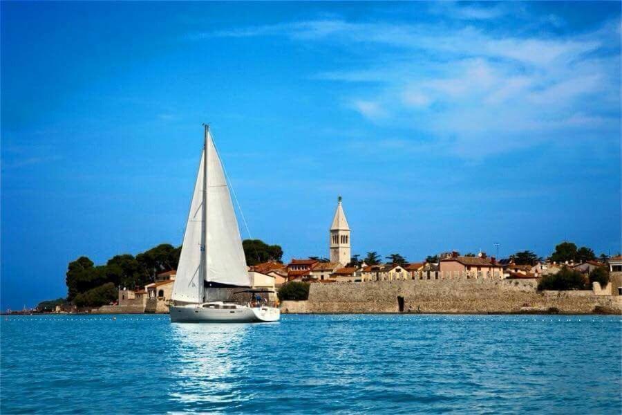 een zeilboot op het water voor een stad bij Guest House Torci 18 in Novigrad Istria