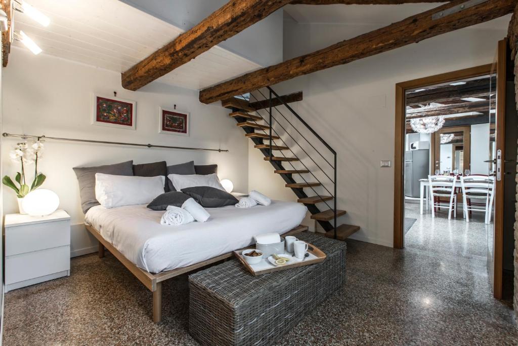 sypialnia z łóżkiem i klatką schodową w obiekcie Design District Apartment R&R w Wenecji