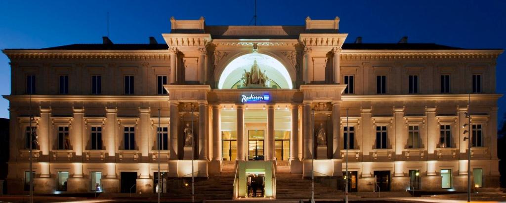 un grand bâtiment avec un panneau devant lui dans l'établissement Radisson BLU Hotel Nantes, à Nantes