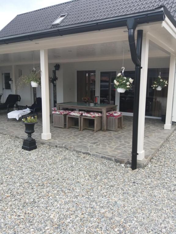un patio cubierto con una mesa con flores. en Casa Martin, en Porumbacu de Sus