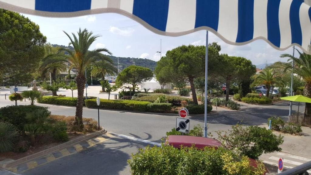uma rua com um sinal de stop e palmeiras em Anatole - T3 - Moderne - Climatisé - 1er étage - Très grande terrasse - Vue magnifique et dégagée em Saint-Mandrier-sur-Mer
