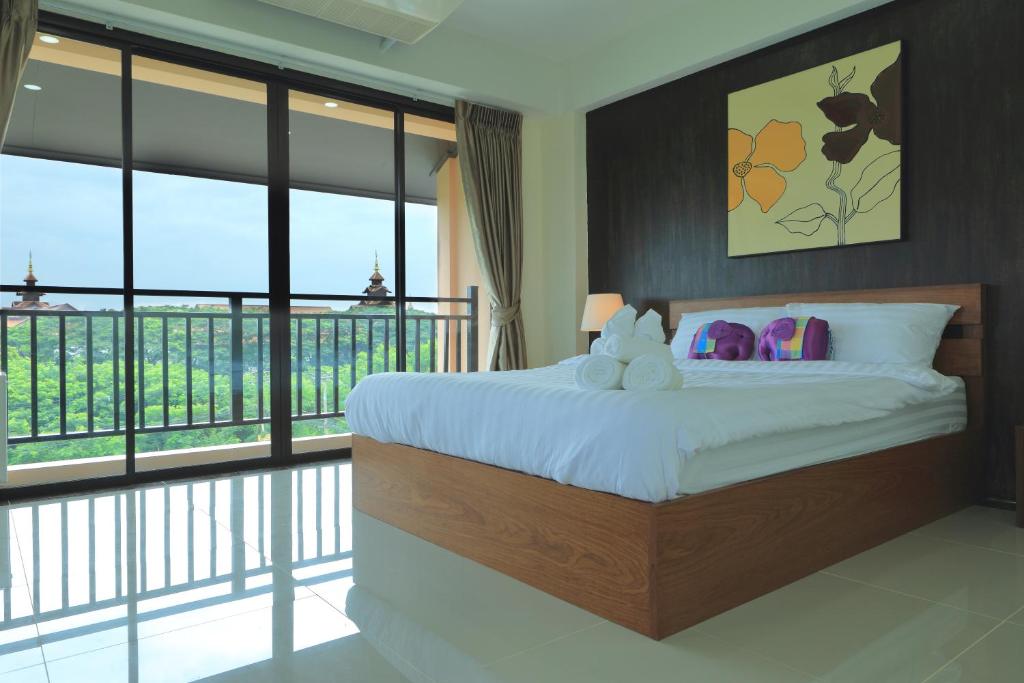 a bedroom with a bed and a balcony with windows at B and Y Residence in Chiang Mai