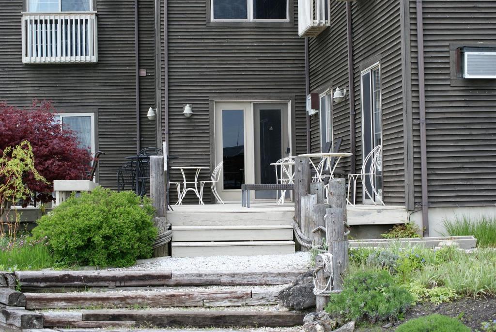 a porch of a house with a table and chairs at Inn on the Harbour and Telegraph House in Port Stanley