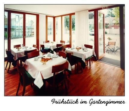 a restaurant with white tables and chairs and windows at Hotel Oberschwaebischer Hof in Schwendi