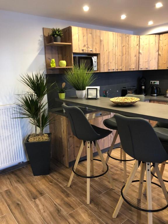 une cuisine avec des placards en bois et un comptoir avec des chaises dans l'établissement Sinsheim Unterkunft, à Sinsheim