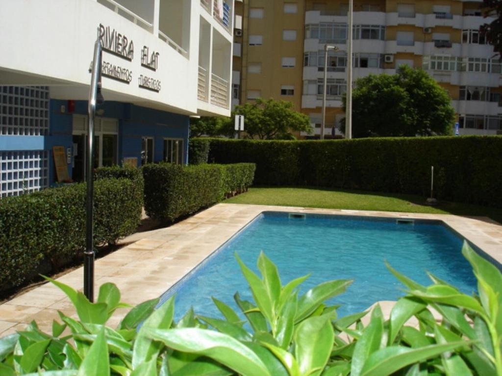 a swimming pool in front of a building at Riviera Flat in Portimão